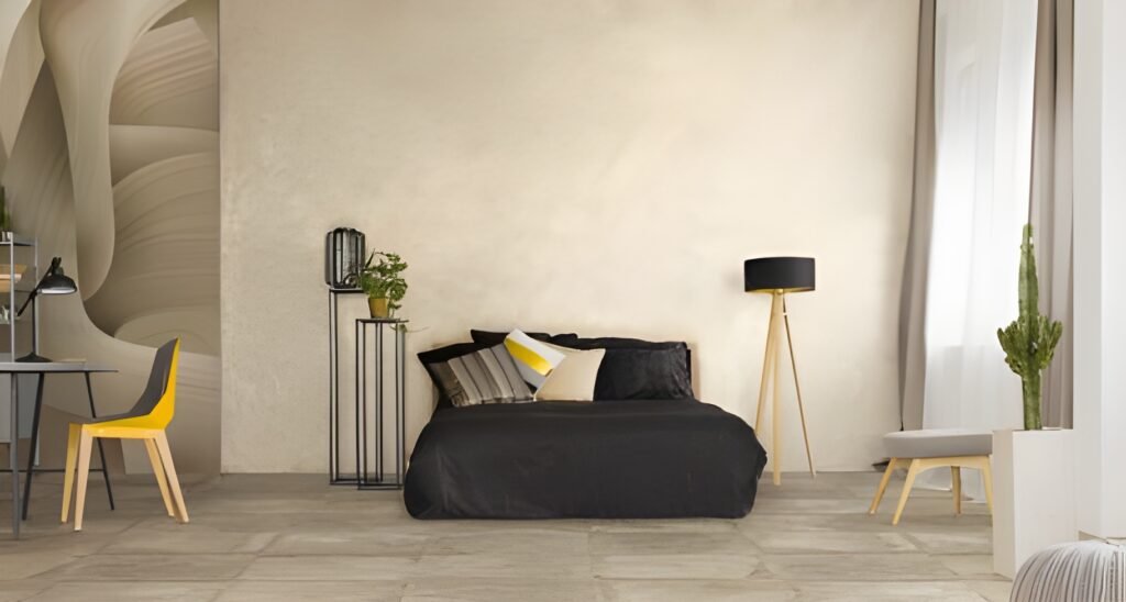 Modern bedroom with a black bed, matt tiles, abstract wall art, and a yellow and grey chair.