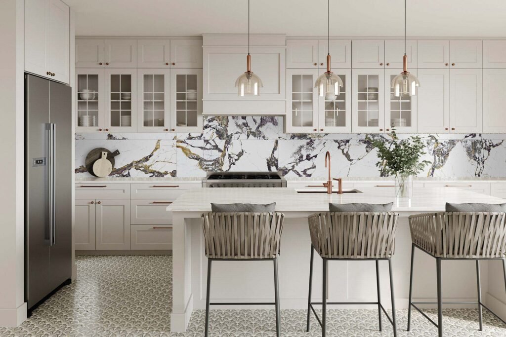 Modern kitchen with white cabinets, marble backsplash, and island. Three pendant lights hang above wicker barstools. Vase with greenery.