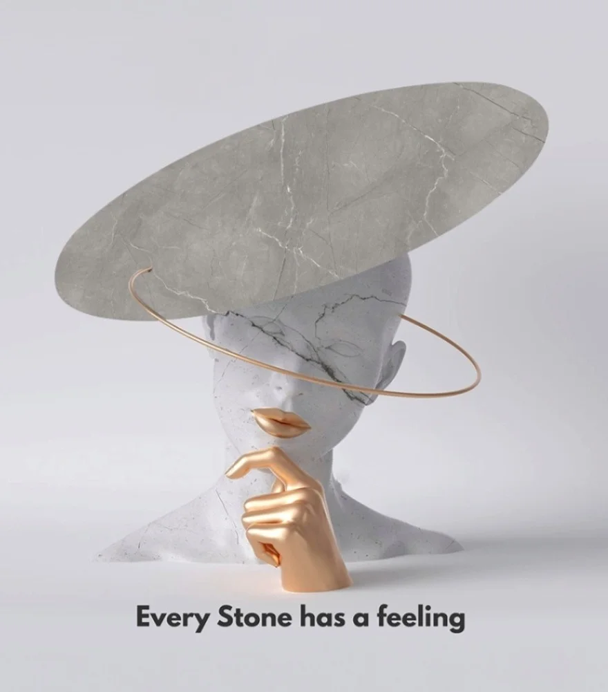Abstract sculpture of a marble head wearing a marble hat, with gold lips and a gold hand touching its chin.