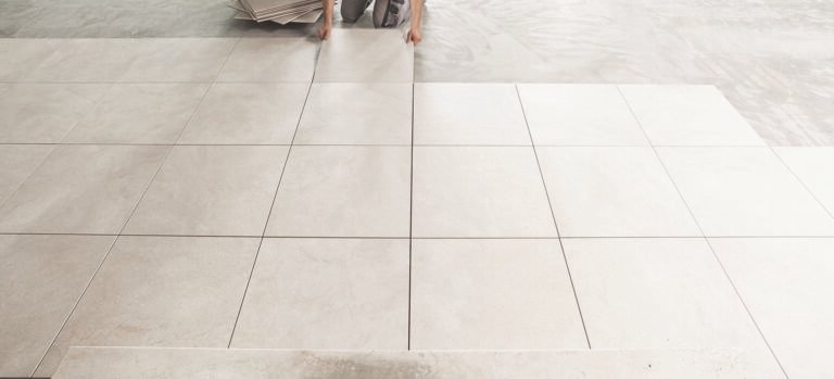 Light gray square tiles are laid out in a grid pattern on a floor.